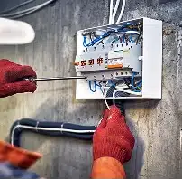 Plumber repairing a faucet beneath a bathroom sink.