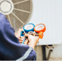 HVAC technician repairing an air conditioning unit outdoors.