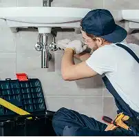 Plumber fixing bathroom faucet.